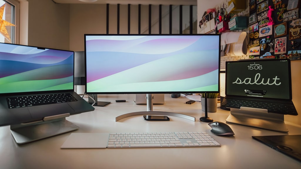 Modern professional workspace with a widescreen monitor, laptop, and tablet