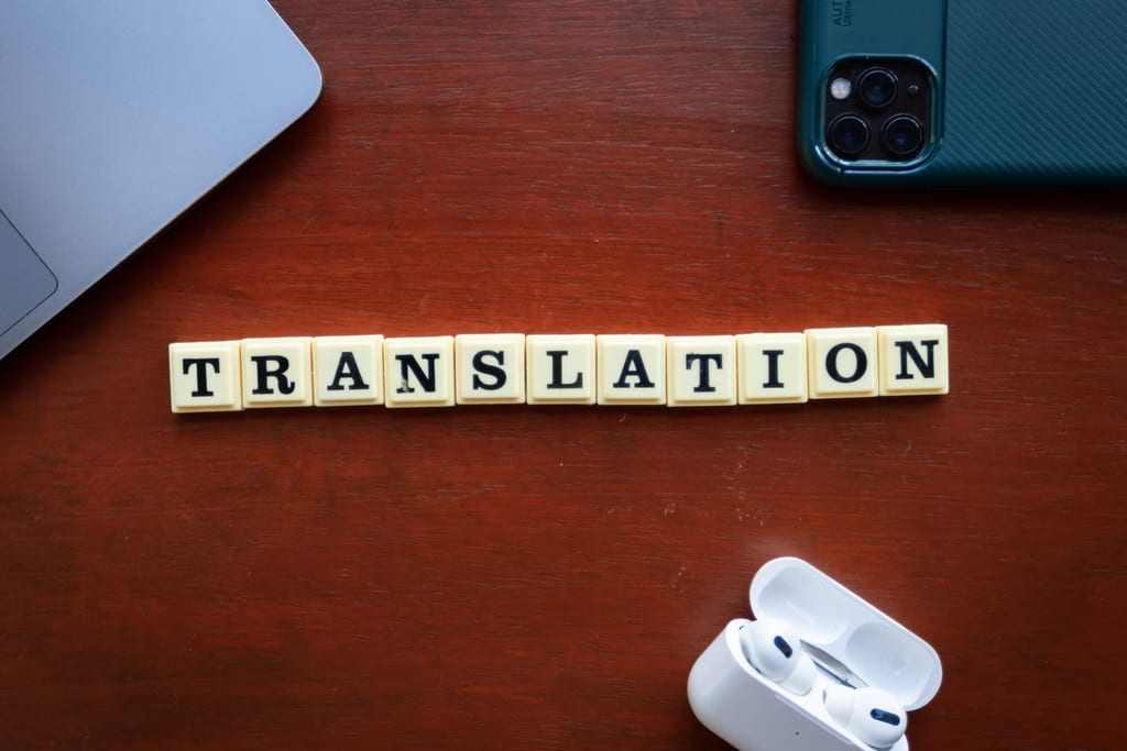 Des lettres du jeu Scrabble formant le mot « translation » sur un plateau en bois
